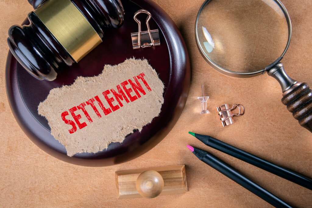 a gavel and the word settlement.  abstract concept to represent a legal settlement.