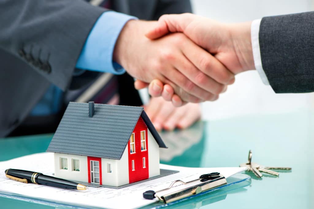 Buyer Agent shaking hands with customer after contract signature